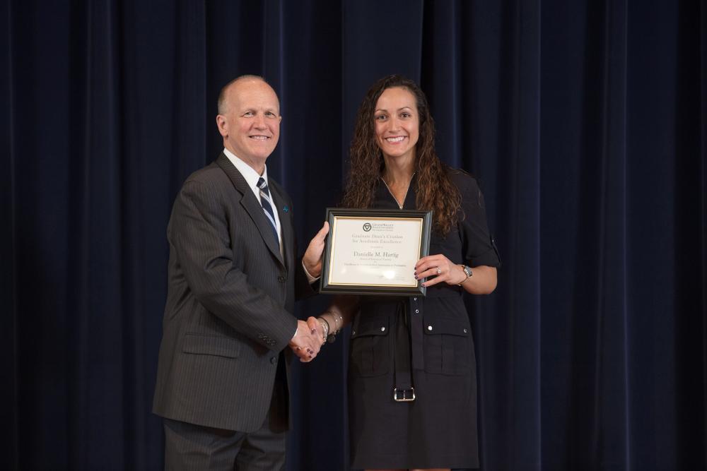 Doctor Potteiger posing for a photo with an award recipient in a black dress with a silver buckle